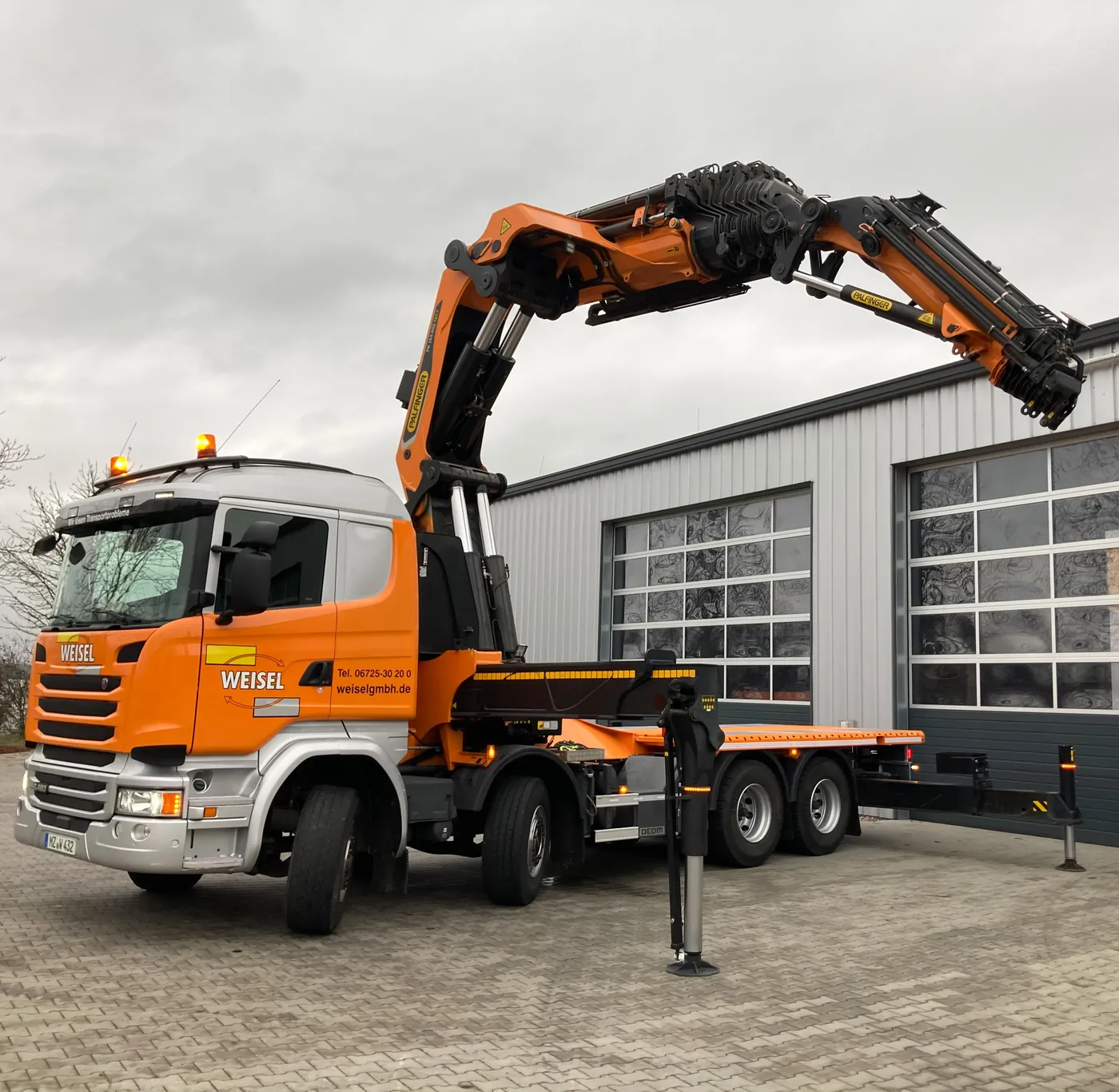 Schwerlast-LKW der Weisel GmbH mit aufgebautem Ladekran auf dem Hof